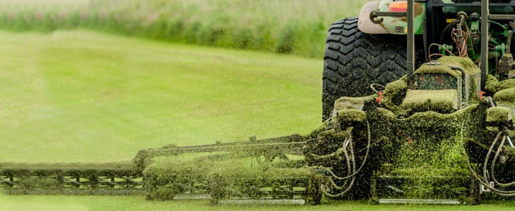 Commercial riding mower cutting grass